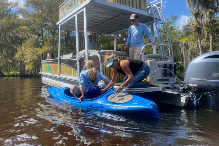 a man riding on the back of a boat in the water