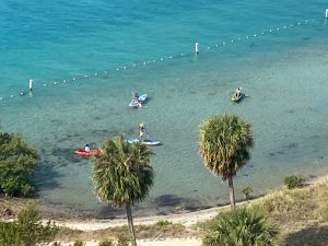 a group of people on a beach near a body of water